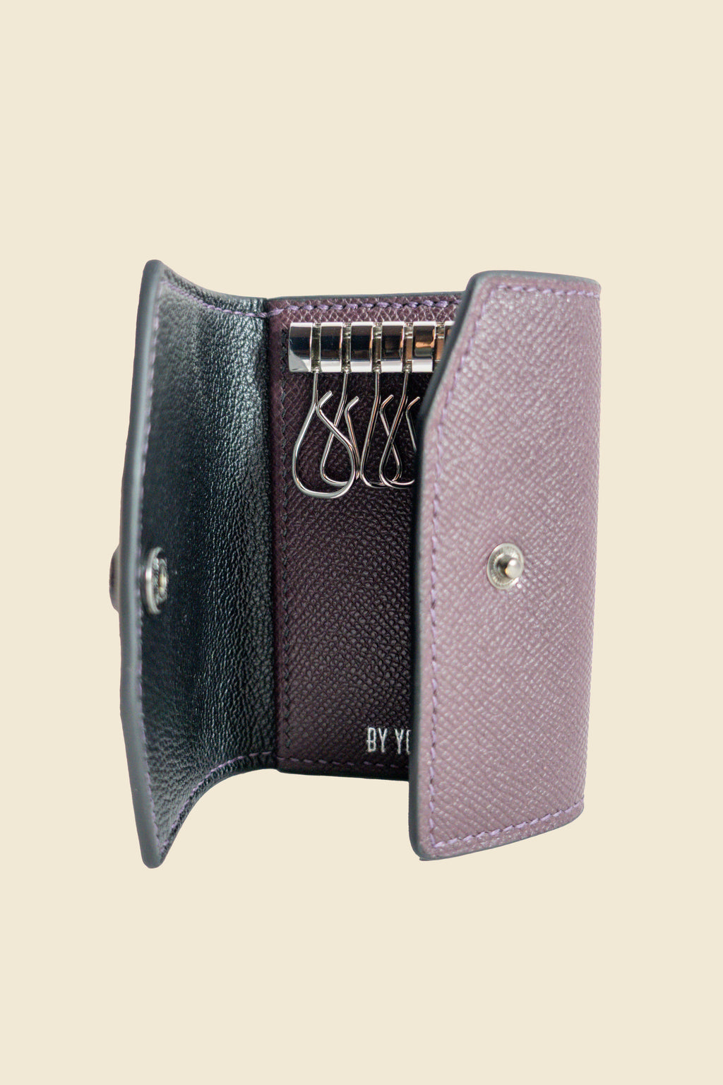 Purple key holder with keys on a beige background